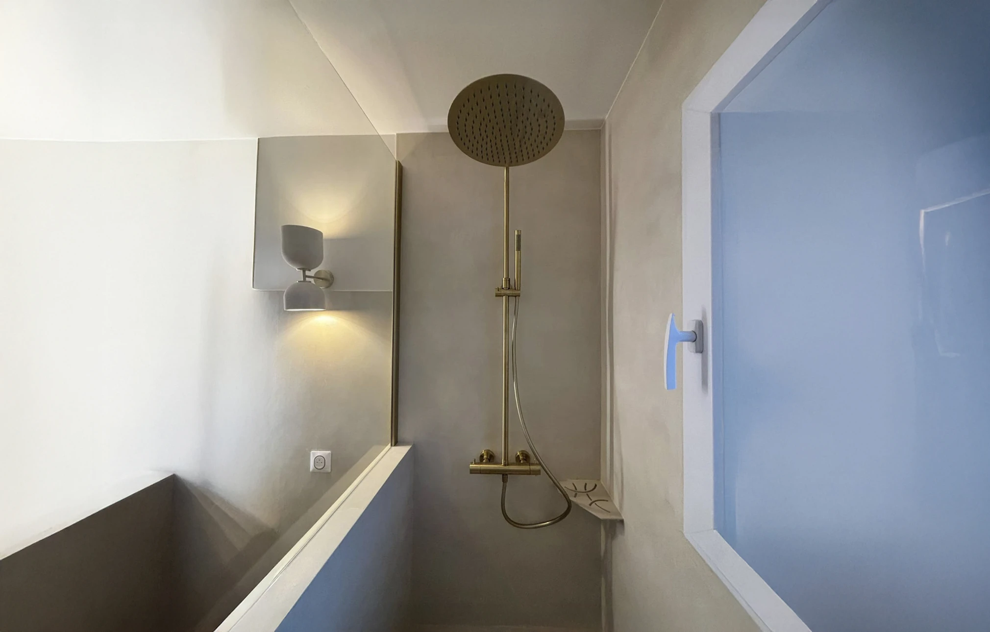 Salle de bains moderne avec douche à l'italienne, murs en béton ciré gris, receveur de douche encastré
