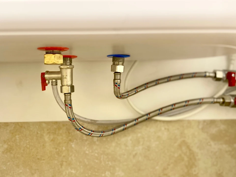 Atelier de plomberie avec outils et raccords disposés sur surface bleue